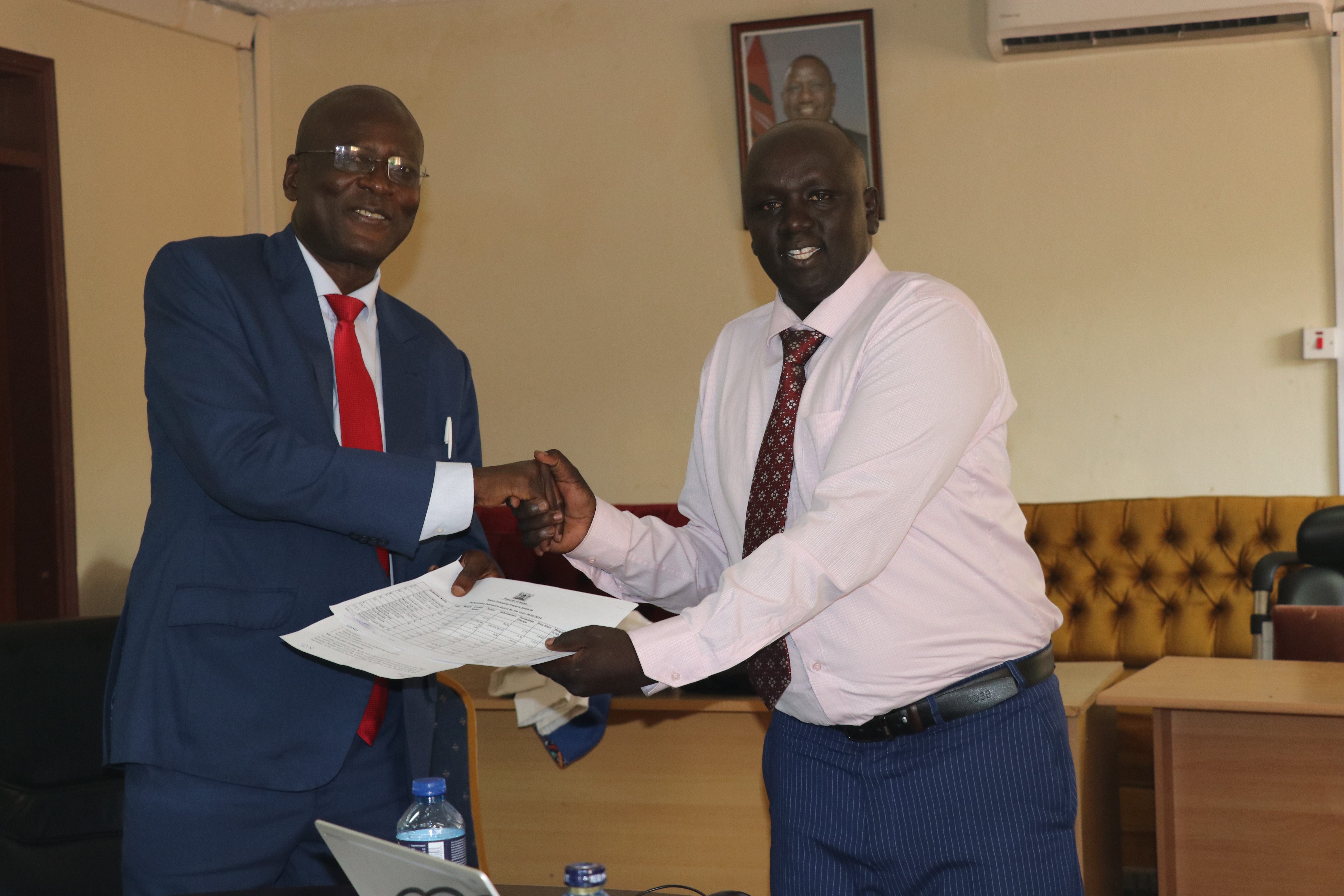 Vincent Sutei (Right), Team Leader of the Evaluators, presents to the Managing Director, John Onyango, a report of their evaluation of the Institute’s performance for the Financial Year 2023-2024